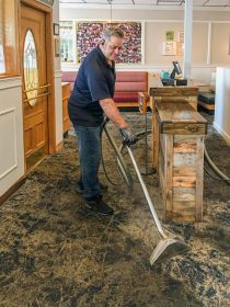 Photo of Greg at Superior Cleaning Systems steam cleaning a commercial restaurant's carpeted floor