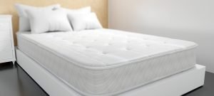 Photo of a white king size mattress with two pillows