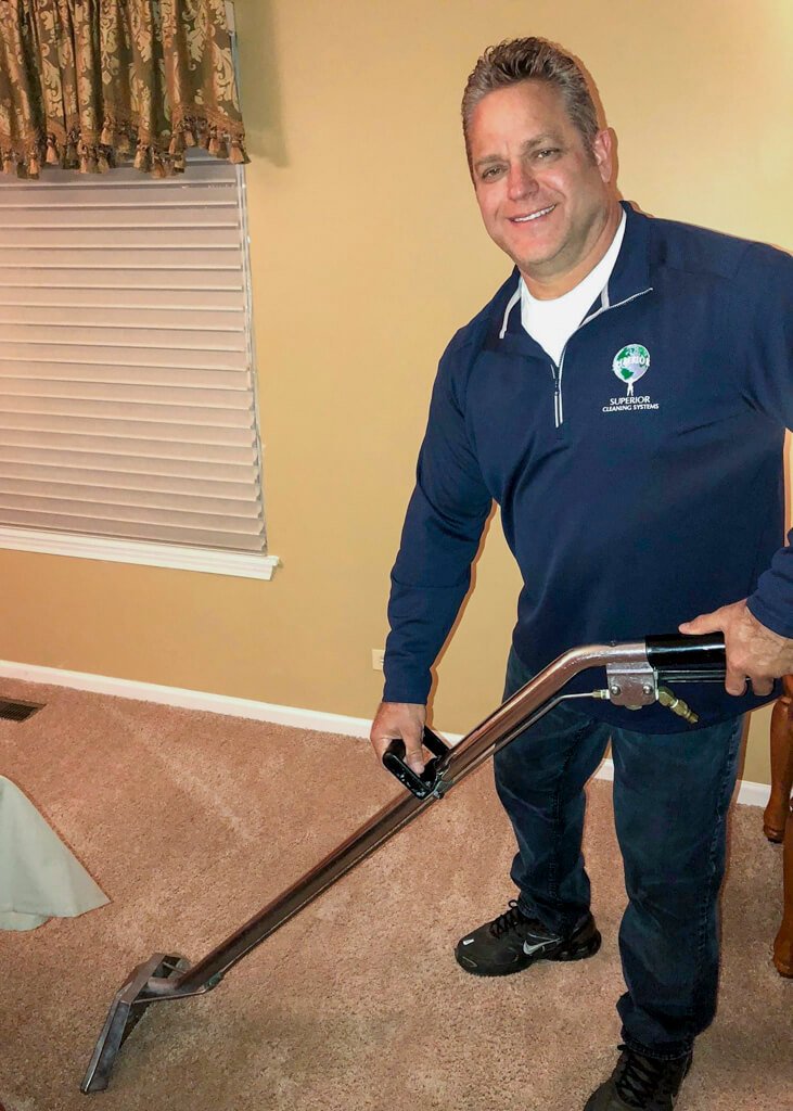 Photo of Greg Gustrowsky, owner of Superior Cleaning Systems, Inc. holding a steam cleaner