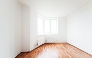 Photo of an empty room with a window and clean white walls and floor